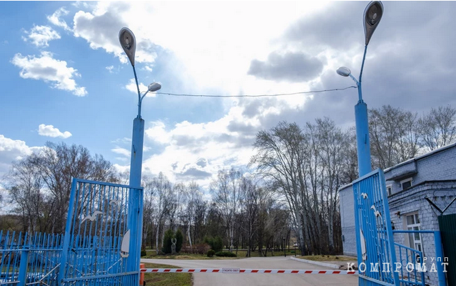 База обнесена зеленым забором с колючей проволокой, но на въезде встречают синие ворота